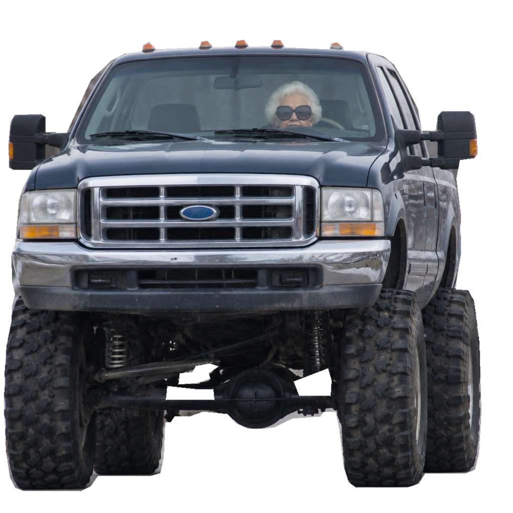 A serene silver-haired Granny in huge sunglasses barely peers over the steering wheel of an enormous lifted blue Ford pickup.